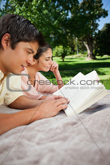 Two friends reading books in a park