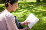 Woman reading a book while sitting in the grass
