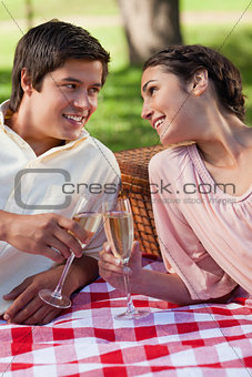 Two friends looking at each other a smiling during a picnic