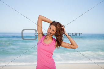 Young woman placing her hands behind her head on the beach