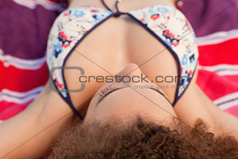 Young attractive woman resting on her beach towel