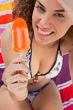Young smiling and attractive woman holding a delicious ice lolly
