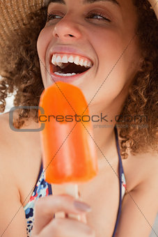 Laughing young woman looking towards the side while holding an i