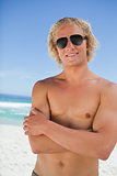 Attractive man crossing his arms while standing in swimsuit