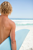 Young blonde man holding his blue surfboard