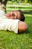 Man lying with his eyes closed and the side of his head resting 