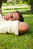 Man smiling while lying with the side of his head resting on his