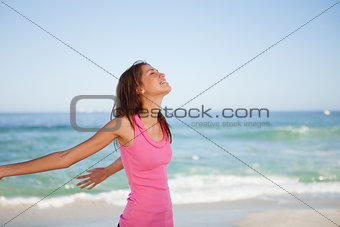 Young woman standing upright while sunbathing on the beach