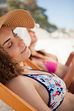 Beautiful woman napping on the beach on a deck chair