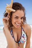 Young woman leaning her head forward while holding a starfish