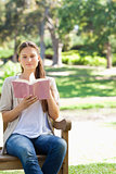 Woman reading a book on a park bench