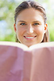 Smiling woman with her book in the park