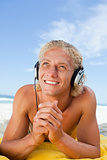 Smiling man looking up while listening to music with his headset