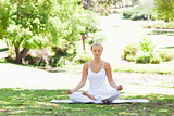 Woman sitting in a yoga position on the lawn
