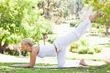 Side view of a woman doing gymnastic exercises on the lawn