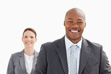 Smiling businessman with smiling businesswoman standing behind