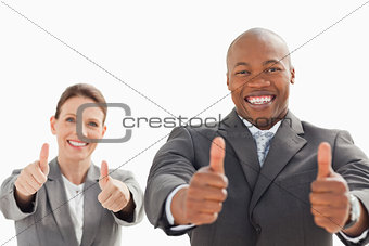 Businessman and woman with their thumbs up