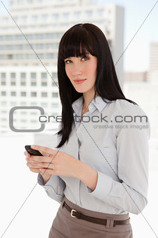 Woman looking in front of her as she sends a text
