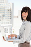 A laughing business woman with a laptop in her hands