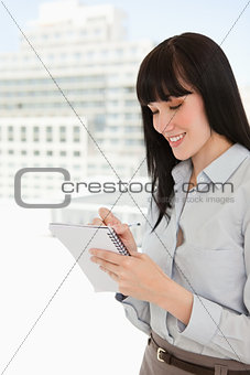 A smiling business woman writing down some notes