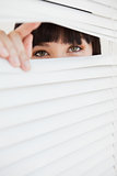 A closed set of blinds with open part opened by a woman 