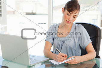 A woman takes down notes on her notepad