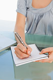 Close up of a woman writing on a notepad