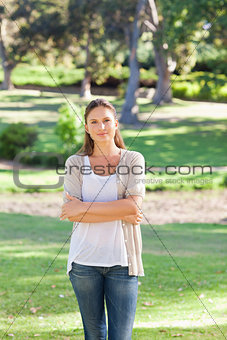 Woman with her arms folded standing in the park
