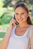 Close up of smiling woman on her cellphone in the park