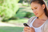 Close up of woman reading a text message in the park