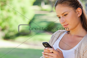 Close up of woman reading a text message in the park