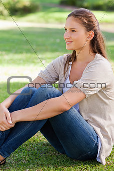 Side view of a woman sitting on the lawn