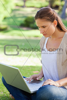Woman sitting on the lawn with her notebook