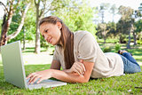 Woman lying on the lawn with her laptop