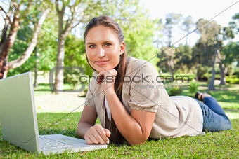 Woman lying on the lawn with her notebook