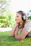Side view of a woman listening to music on the lawn