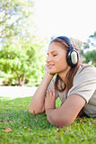 Side view of a woman enjoying music on the lawn