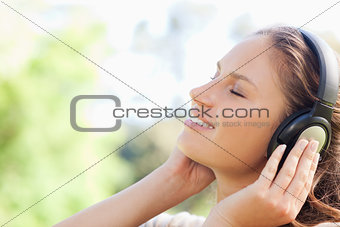 Side view of a woman enjoying music in the park