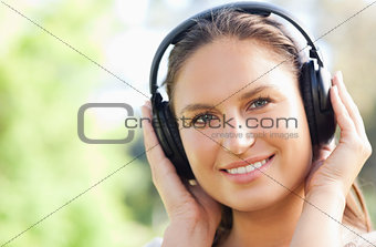 Close up of a woman listening to music in the park