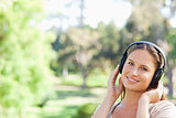Smiling woman in the park listening to music