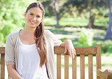 Smiling woman sitting on a park bench