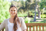 Smiling woman relaxing on a park bench