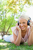 Smiling woman enjoying music on the lawn