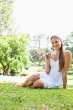 Smiling woman sitting on the grass in a park