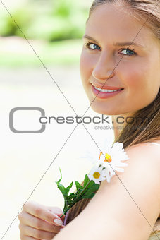 Close up of a smiling woman with a flower
