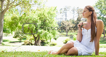 Woman sitting on the grass with a flower