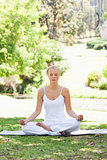 Woman sitting in a yoga position on the grass