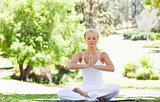 Woman in a yoga position sitting in the park