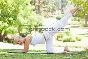 Side view of a woman doing gymnastic exercises in the park