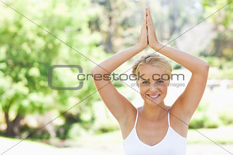 Relaxed smiling woman doing yoga in the park